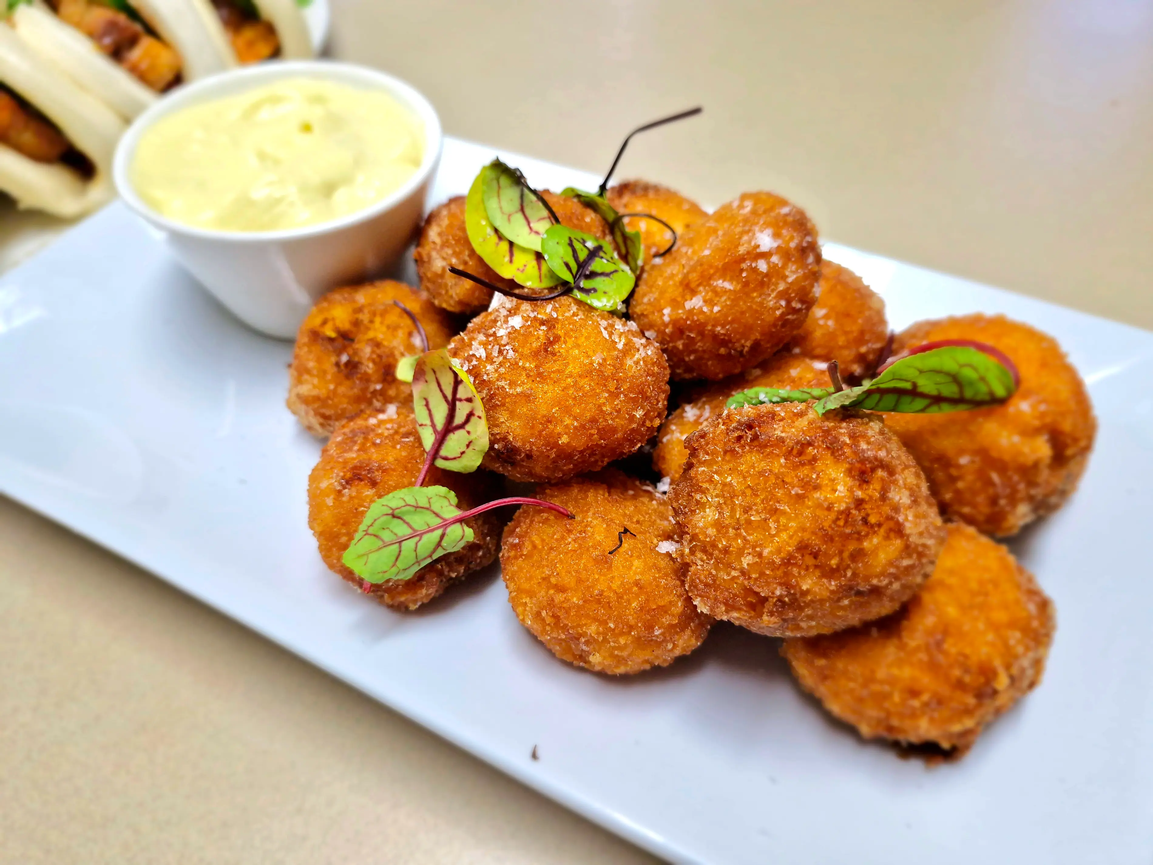 Platter of golden arancini balls with dipping sauce prepared for a corporate catering event in Toowoomba